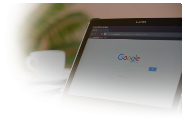 samsung tablet with google search open on a table with a coffee cup on the table and a plant in the background