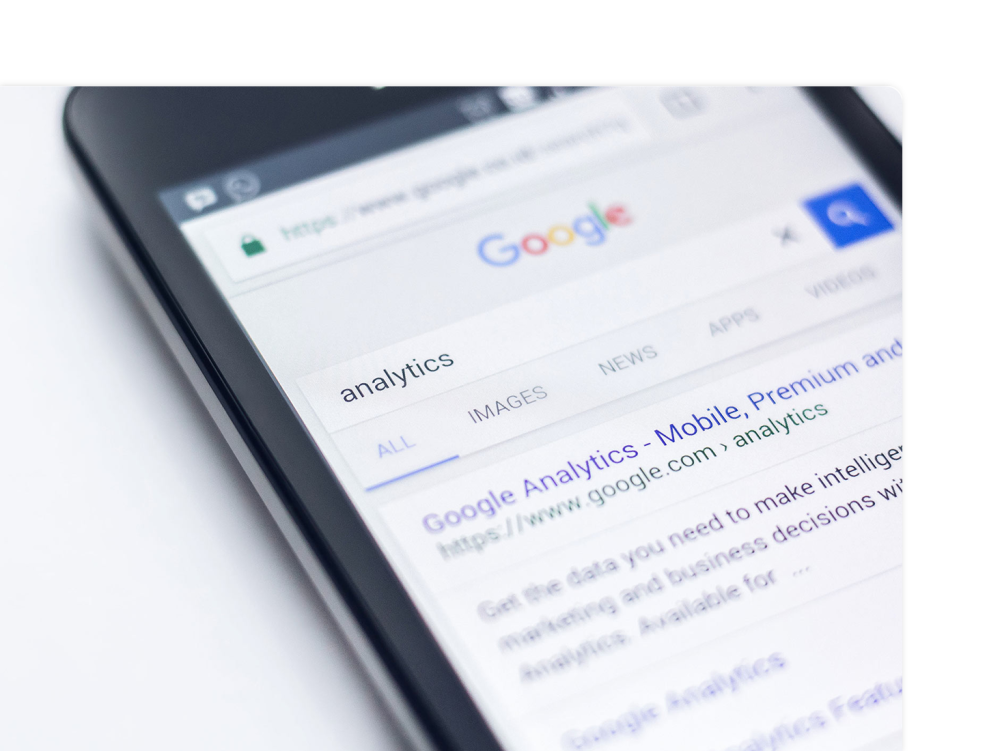 a phone with a google search with the word analytics in the search bar