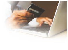 a man holding a credit card ordering something online with a laptop in front of him