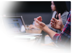 two people discussing a project at a table pointing to our flagstaff website design team – faded on left and bottom