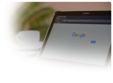 samsung tablet with google search open on a table with a coffee cup on the table and a plant in the background